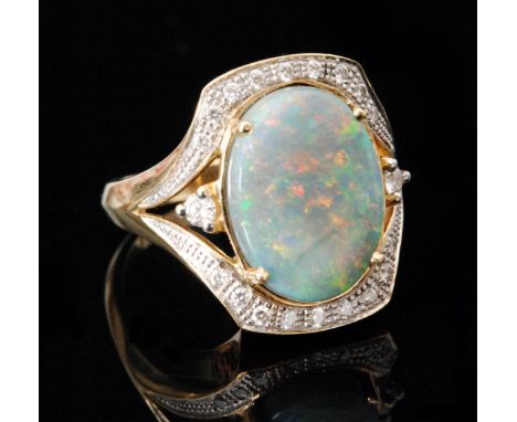 An 18ct opal doublet and diamond ring, central oval opal claw set within diamond set border with a single diamond to each spl