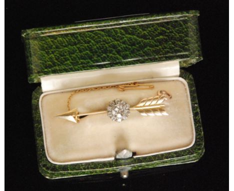 An early 20th Century diamond brooch modelled as an arrow with a central eleven stone old cut diamond cluster largest stone a