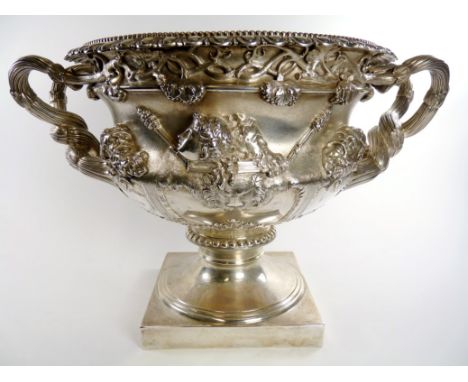 An early 20th Century hallmarked silver Warwick vase decorated with portrait and mask details below fruiting vine and gadroon