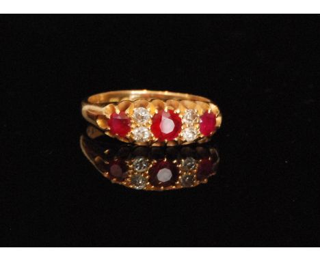 An early 20th Century 18ct hallmarked ruby and diamond seven stone boat shaped ring, three rubies spaced by pairs of diamonds