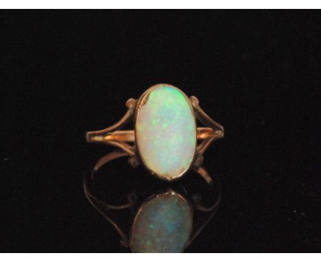 An early 20th Century 9ct opal ring, the oval cabochon collet set to forked scroll shoulders and plain band, weight 1.6g, rin