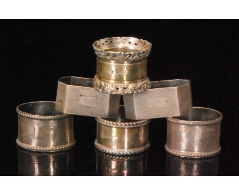 Six early 20th Century and later hallmarked silver napkin rings to include two engine turned decorated pairs, various styles 