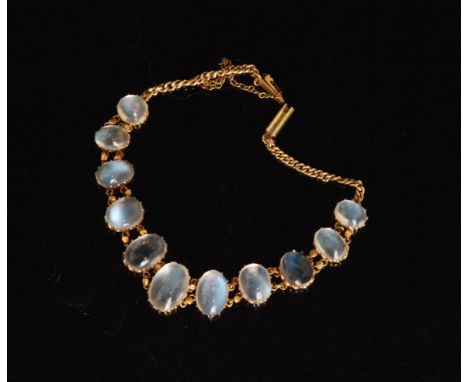 A gold mounted moonstone bracelet formed of eleven graduated oval moonstones and terminating in a fine foxtail chain with ton