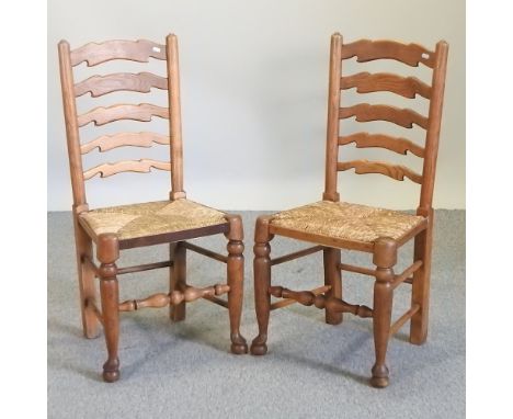 A set of six oak ladder back rush seated dining chairs