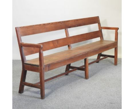 An early 20th century pitch pine bench, with cushion, 232cm