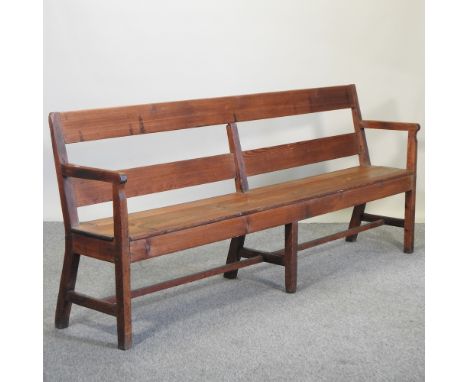 An early 20th century pitch pine bench, with cushion, 232cm