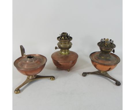 An early 20th century copper oil lamp, in the manner of WAS Benson, 15cm high, together with two others similar