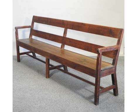 An early 20th century pitch pine bench, with cushion, 232cm
