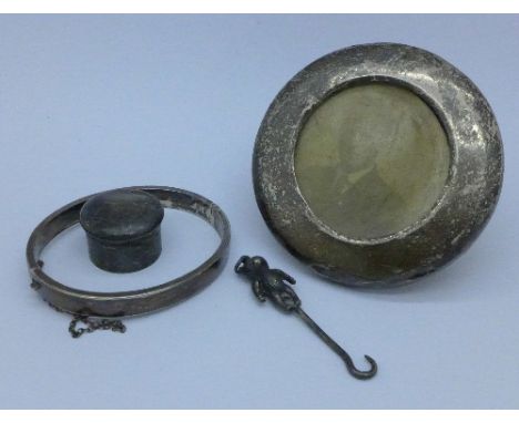 A silver pill box, Birmingham 1907, a silver bangle, a silver photograph frame and a silver Teddy bear button hook, Birmingha