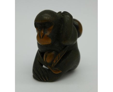 A carved netsuke of a chimpanzee, signed