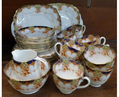 A Wellington china tea service, comprising two cake plates, eleven side plates and cups, twelve saucers, sugar and cream