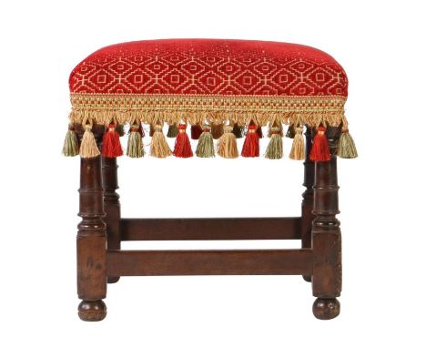 A Charles II oak and upholstered stool, circa 1660The square stuff-over seat upholstered in crimson geometric fabric with tas