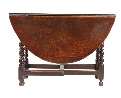 A Charles II oak gateleg table, circa 1680Having an oval drop-leaf top, on simple gates, with ring and baluster-turned legs, 