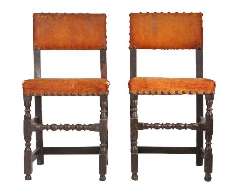 A pair of Charles II oak and hide upholstered chairs, circa 1670

Each with rectangular padded open back and stuff-over seat,