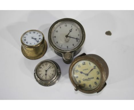 Four dashboard clocks,comprising a small white enamel dial clock in angled brass mount, 5cm diameter lens (in working order a