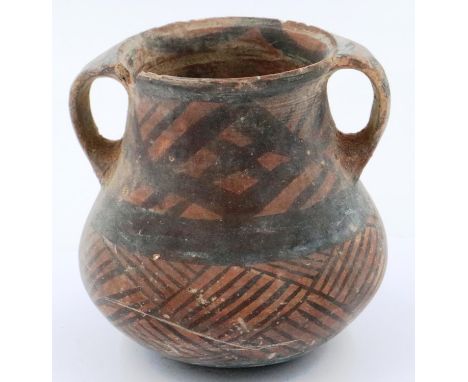 A Neolithic period painted terracotta twin handled pot, decorated with geometric designs, H: 10 cm, D: 9 cm. Loss to rim. P&P