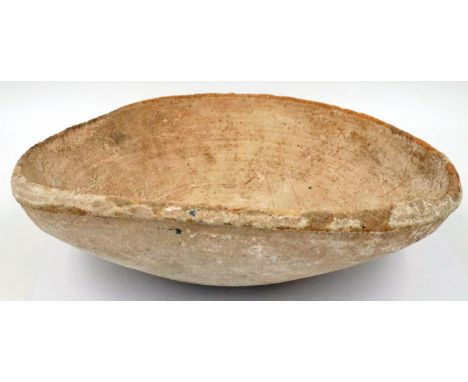 A very large Han Dynasty bowl or receptacle, off-circular and undecorated, D: 30 cm, H: 9 cm. Some minor losses to the rim. P