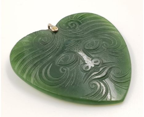 A jade heart pendant with carved decoration. 27.2g. 