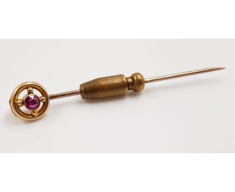 A 9ct gold stick pin; with small ruby. Weighs 2.4g and is 5cm. 