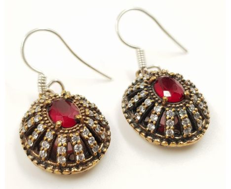 A pair of silver dress earrings with diamond and ruby like decoration. 9.4g total weight. 