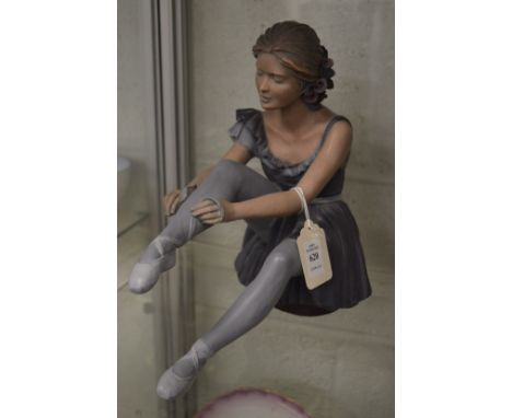 A limited edition Continental pottery model of a seated ballerina.