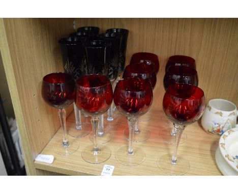 Two sets of ruby colour drinking glasses.