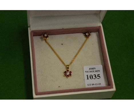 A gold diamond and ruby flower head pendant with chain together with a pair of matching earrings.