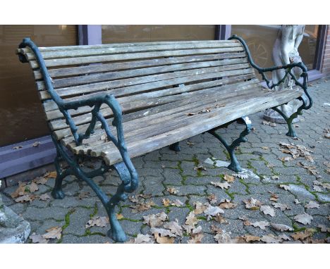 A large garden bench with wooden slats and cast iron supports.