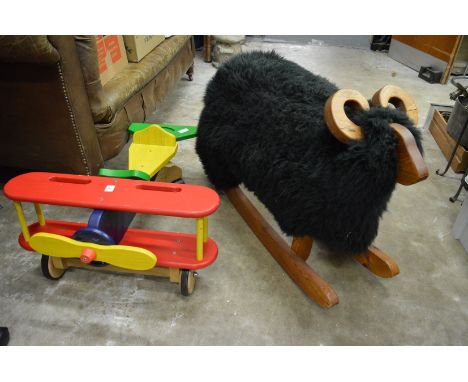 A childs painted wood model biplane and a rocking ram.