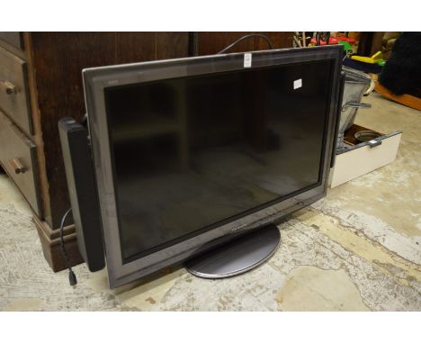 A flat screen TV with speaker system and accessories.