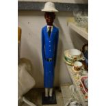 A carved and painted wood standing figure of a policeman.