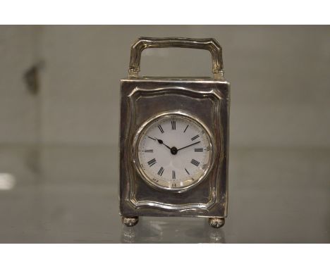 A small silver carriage type clock.