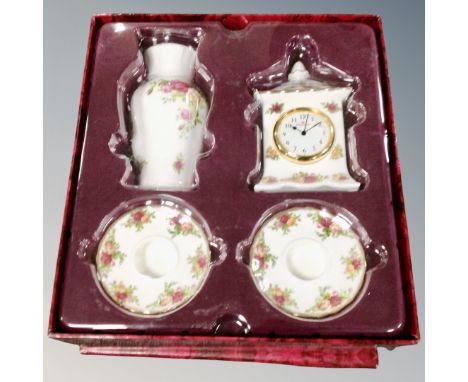 A Royal Albert Old Country Roses four piece candle stick and mantel clock and vase set in box.