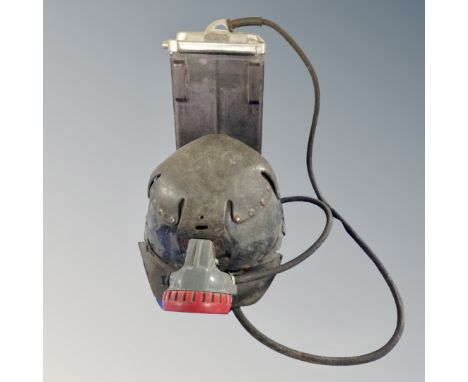 A vintage coal miner's helmet with lamp and battery pack