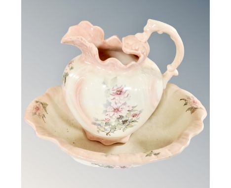 An English pottery pink rose patterned wash jug and basin.