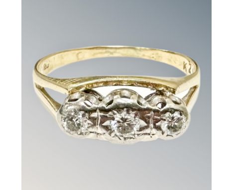 An 18ct gold and platinum three-stone diamond ring, the three brilliant-cut stones in a raised illusion setting, size Q.  CON