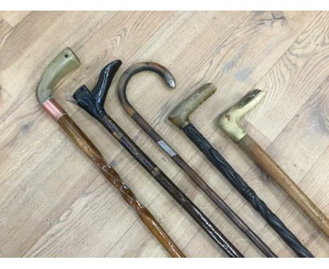 Silver mounted walking stick, together with three walking sticks with horn grips and another modelled as a boot (5)