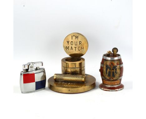 A brass match-striker stand, an Omega blue and red pocket lighter, and a souvenir barrel design table lighter (3) 