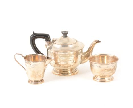 A silver three-piece teaset by Viners, Sheffield 1964, circular polished form with three-line band and fan-shaped motif suppo