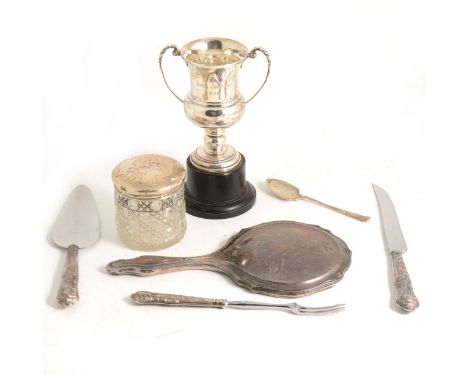A silver trophy cup and other small silver wares, a glass jar with silver cover, cake slice, bread knife and pickle fork with