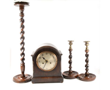 An oak cased mantel clock, silvered dial, movement striking on a gong, 3cm; a pair of oak barleytwist candlesticks; and an oa