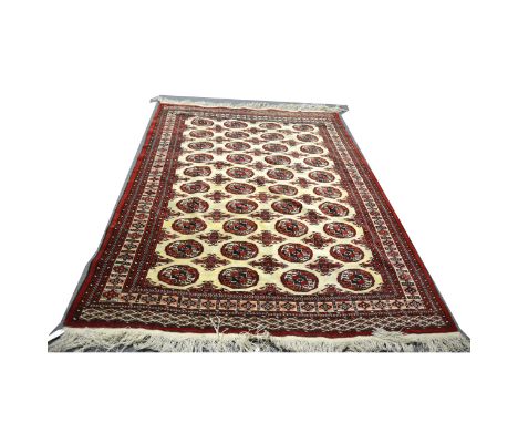 A small Bokhara carpet, with four rows of ten guls on an ivory coloured field, border within guards, 274cm x 196cm.