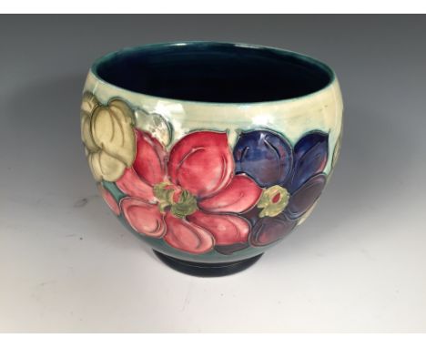 A Moorcroft Clematis pattern planter, the bulbous form raised on a small circular foot, decorated on a green into blue ground