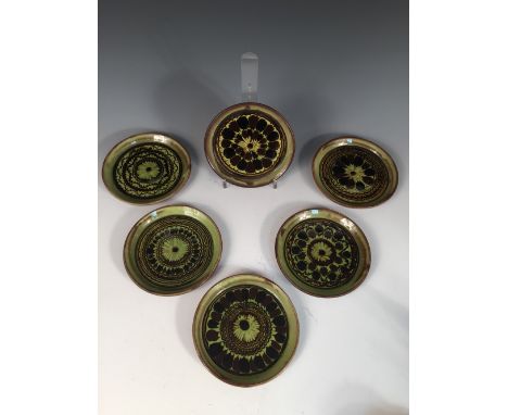 Sidney Tustin for Winchcombe Pottery, a set of six slipware side plates, each of circular form with radiating designs, impres