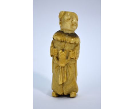 A Japanese stag-antler, or other, netsuke carved as a Manchu/Chinese boy looking slightly to the left and riding a Hobby Hors