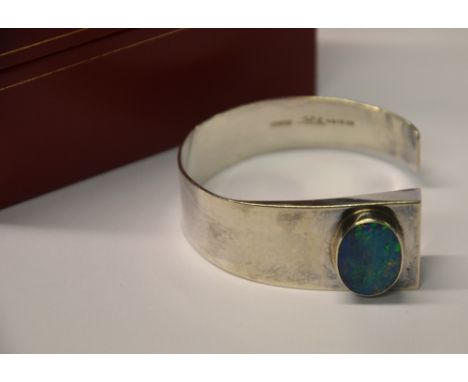 A contemporary open style bangle set with oval opal, stamped STG.SIL and signed Condition Report Design, illegible signature,