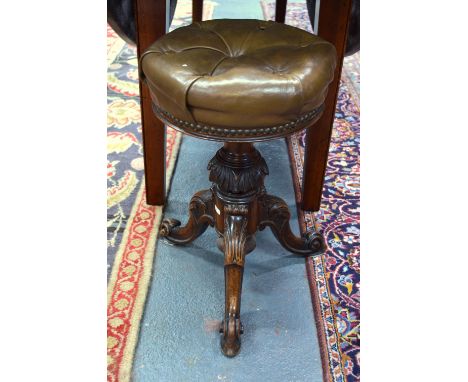 A Victorian carved and moulded walnut tripod revolving piano stool, the buttoned leather seat stamped to the underside '4089'
