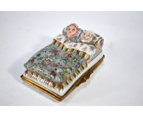 Chantilly, France - A 19th century rectangular porcelain pill/snuff box, the top moulded and painted as a couple in bed, gilt