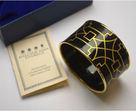 A Halcyon Days gilt metal and black enamel bangle, approx 4 cm wide x 6.7 cm diam, in fitted box
