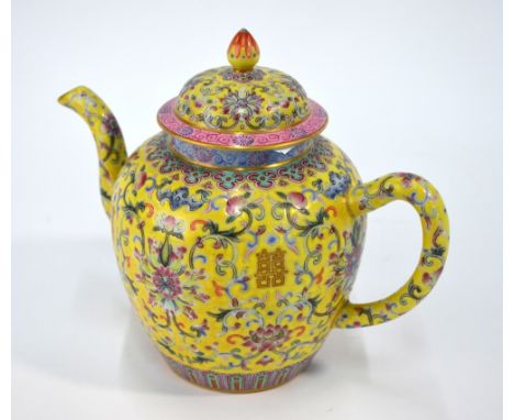 A Chinese yellow ground, famille rose teapot with domed cover and knop finial, decorated with formal lotus and peaches; 22 cm